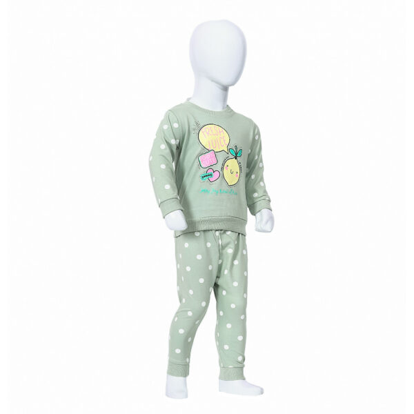 A green sweater and pants set for a child, featuring a lemon design on the sweater with the text "Fresh Fruits". The pants have a polka dot pattern.