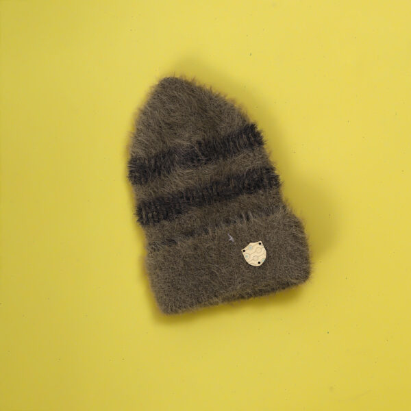 Grey fuzzy hat with stripes and a shield decoration